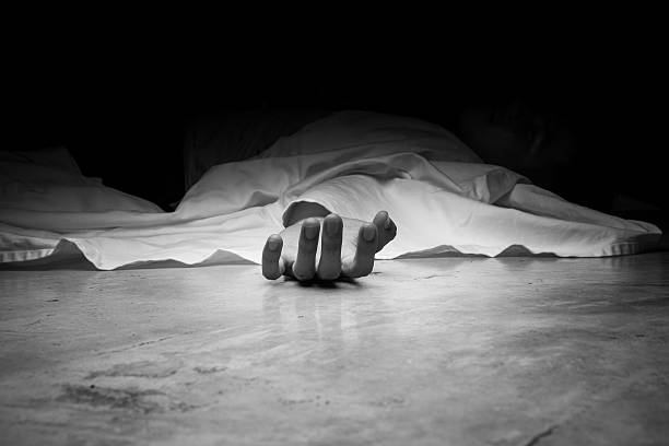 The dead man's body. Focus on hand