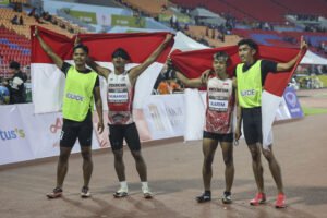 Ekspresi atlet NPC Indonesia,  Taufik Abdul Karim (dua dari kanan) dan Ruli Al Kahfi Mubaroq bersama pendampingnya seusai menyelesaikan pertandingan lari 100m putra T11 ASEAN Para Games 2025 di Aquatic Centre 80th Birthday Anniversary Commemorative Stadium