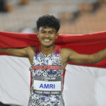 Atlet NPC Indonesia Rezza Surya Amri berpose dengan Bendera Merah Putih setelah berhasil memenangkan pertandingan nomor lompat jauh T46, T47 ASEAN Para Games 2025 di 80th Birthday Anniversary Commemorative Stadium di Nakhon Rachatsima, Thailand, Sabtu (24/